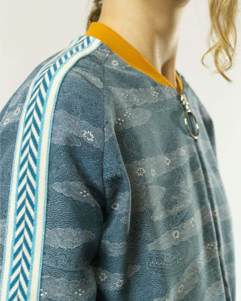 Nahansicht von blauer Bomberjacke aus Kimono mit ockergelbem Kragen und blau gemustertes Zierband