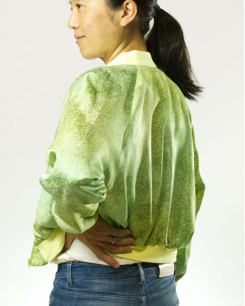 Seitenansicht von Frau mit hellgrüner Bomberjacke aus Kimono mit hellgelben Punkten und hellgelben Bündchen